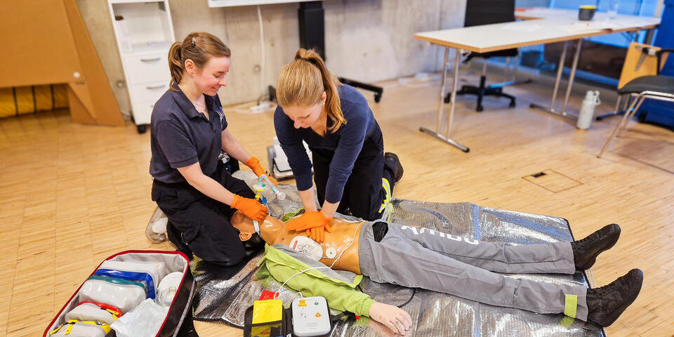 Zwei junge Frauen über an einer Übungspuppe Wiederbelebung