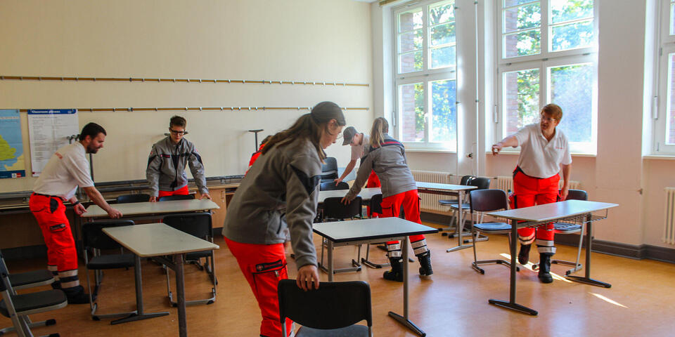 Einsatzkräfte richten einen Klassenrum ein