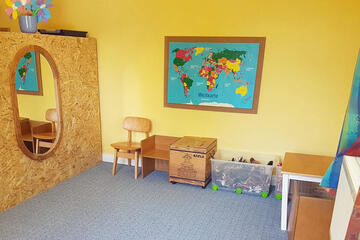 Landkarte an der Wand, Teppich zum Spielen und einige Spielsachen in den Schränken. 