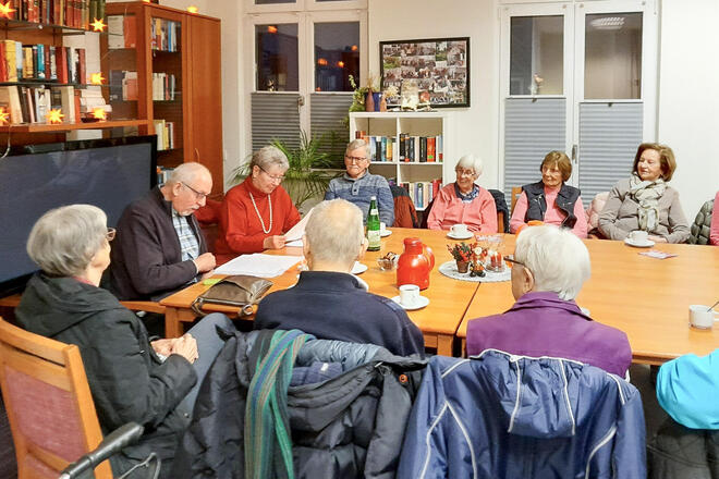 Die Bewohnerinnen und Bewohner sitzen an einem Tisch zusammen und erzählen sich Geschichten auf Plattdeutsch.
