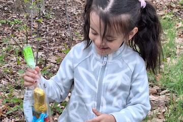 Ein Mädchen hält eine Tüte mit Osternaschzeug in der Hand.