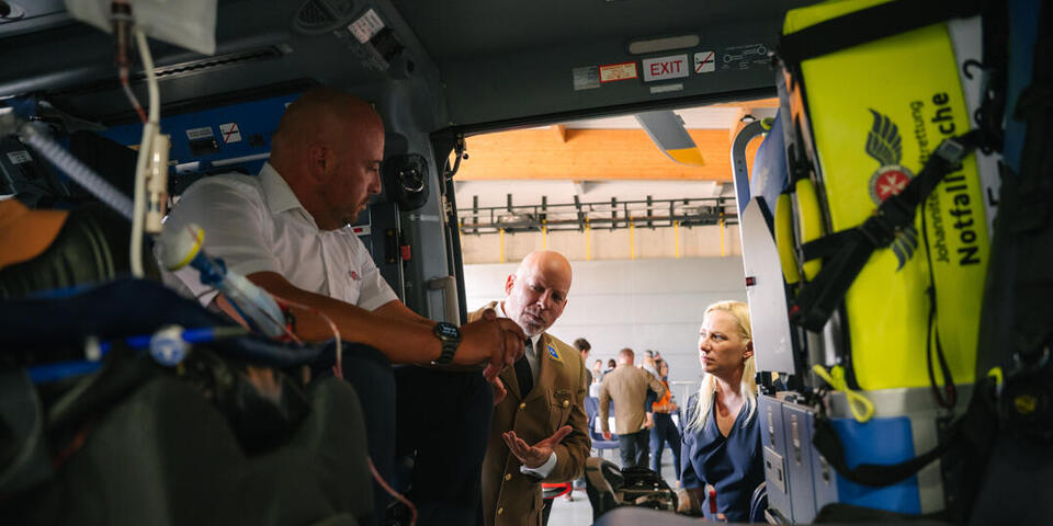 Staatsministerin Stolz lässt sich Geräte und Vorgehensweisen in der Luftrettung erläutern von Geschäftsführer Zabell und Bereichsleiter Jabs. 