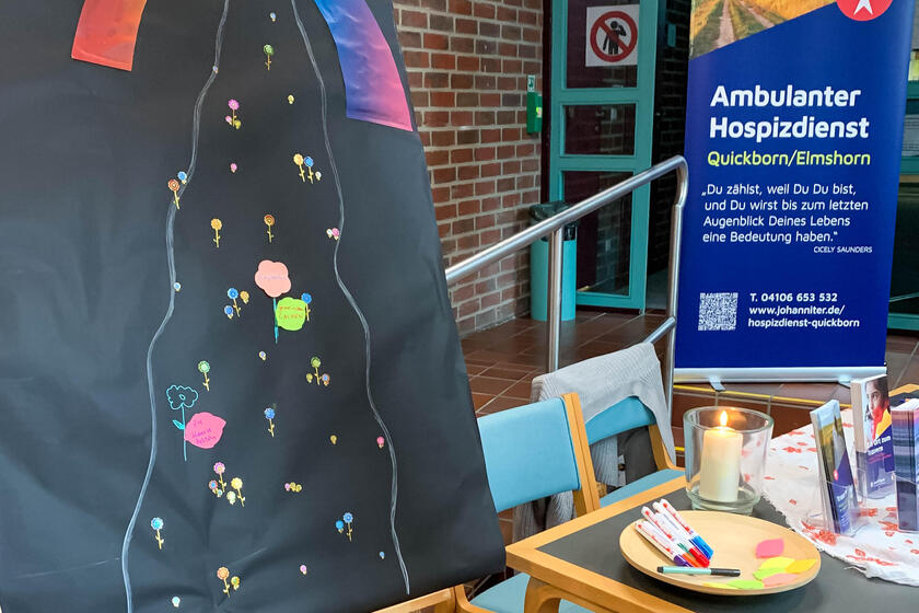 Infostand der Johanniter mit einem Tisch, Rollup und einer Tafel.