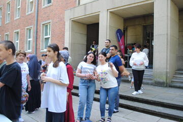 Gruppenfoto mit lachenden Besucherinnen und Besuchern vor dem Eingangsbereich.