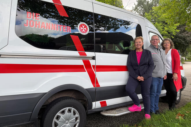 Drei Johanniter der Dienststelle vor Johanniter-Fahrzeug