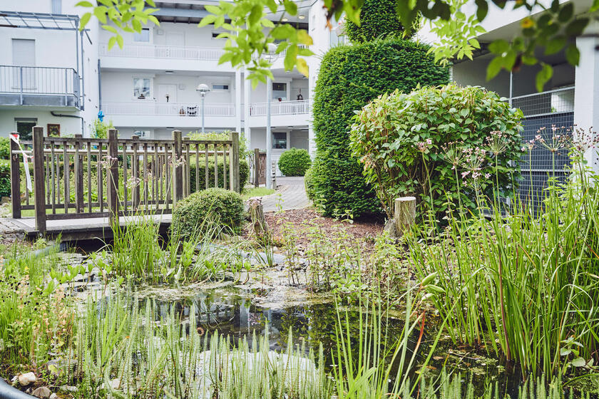 Schön angelegter Garten, Johanniter-Stift Duisburg Blick zum Teich und Holzbrücke zum Eingang des Johanniter-Stift Duisburg