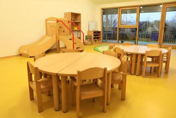 Gruppenraum mit Tischen und Rutsche in der Johanniter-Kinderkrippe "Turmwichtel" Bad Abbach