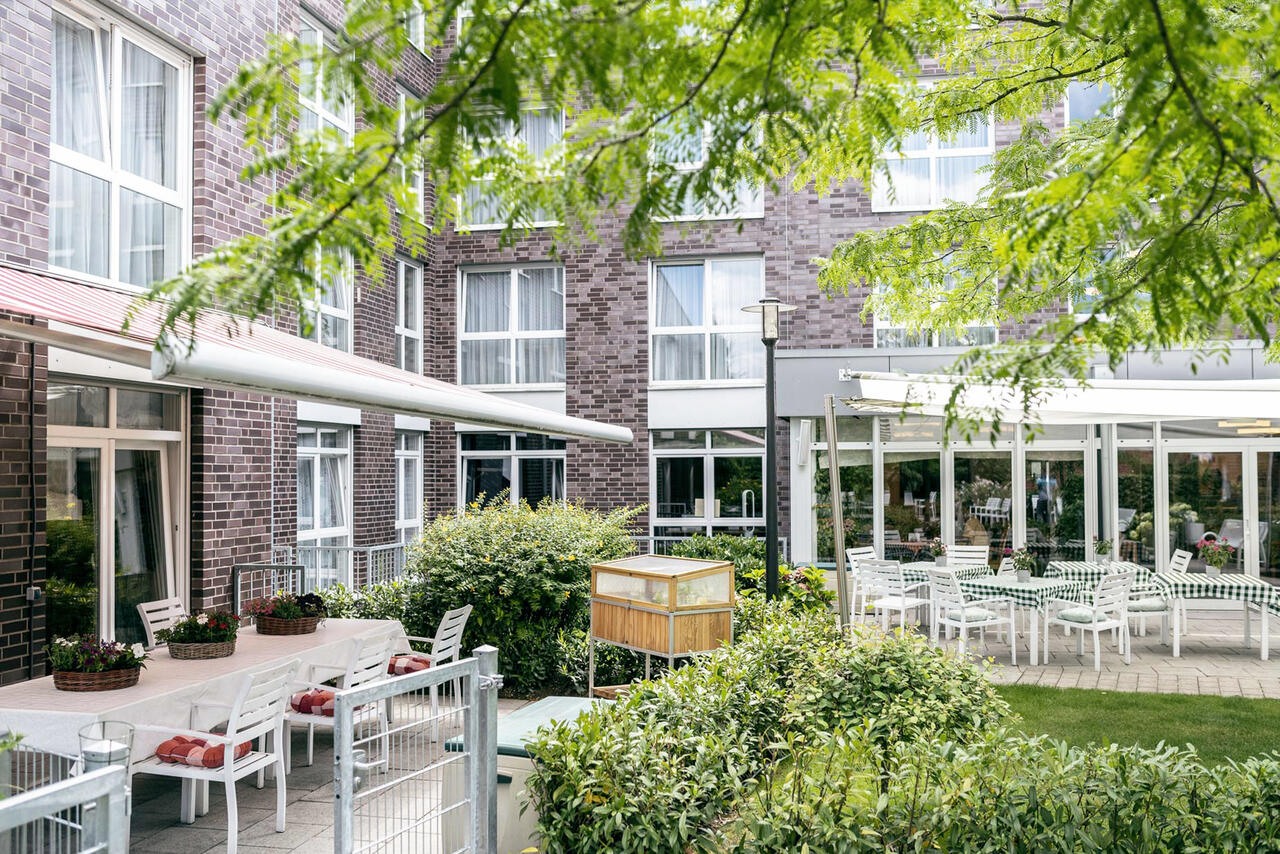 Überdachte, einladende Sitzgelegenheiten im Garten des Stiftes