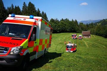 Ein Rettungswagen steht auf einer Wiese vor einer malerischen Kulisse bei Bad Hindelang