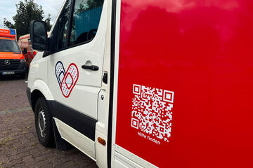 QR Code auf der Seite des Pflasterlasters zu Hilfsangeboten für Wohnungslose