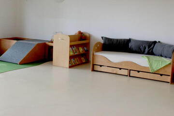 Bauteppich, Spielsachen und gemütliches kleines Sofa. 