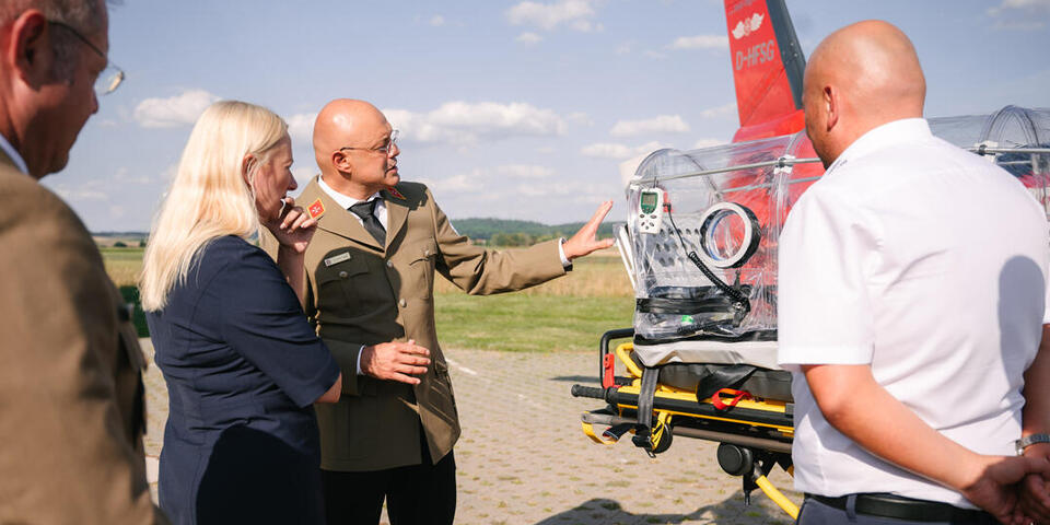 Mumi Taleb erklärt Ministerin Stolz Bestandteile der Ausstattung.