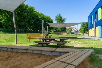Außengelände mit Spielgeräten und Sandkasten der Johanniter-Kita Seehüpfer