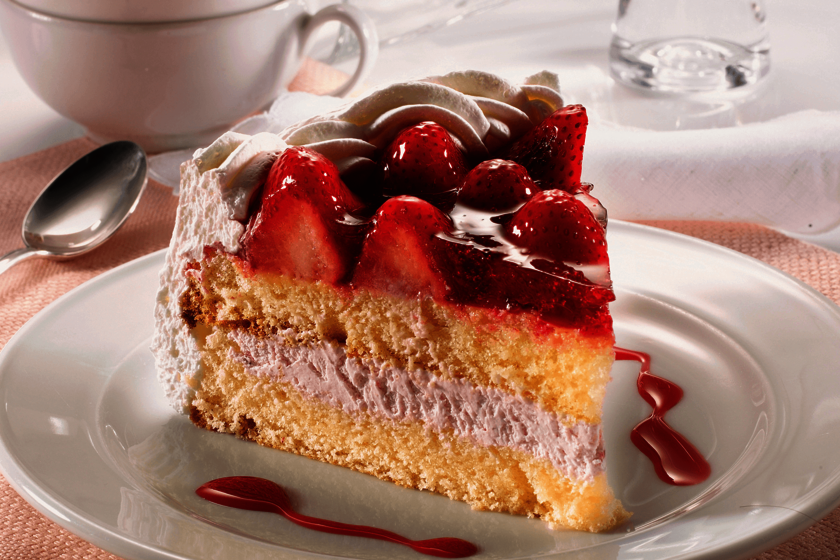 Kaffee & Kuchen ein Stück Erdbeertorte auf einem Teller
