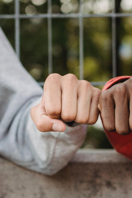 Zwei junge Menschen geben sich einen Faustgruß