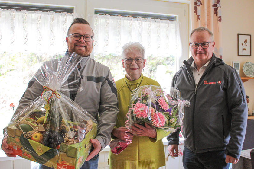 Ein Johanniter mit Präsentkorb, eine Dame mit Blumenstrauß und ein weiterer Johanniter