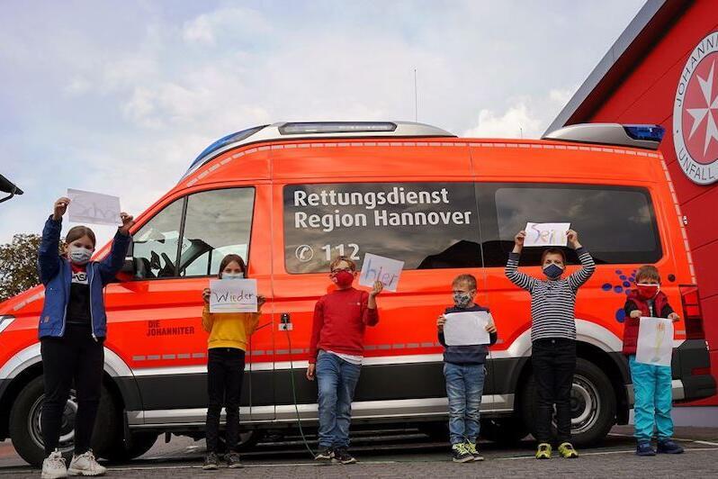 Jugendgruppe vor einem Krankenwagen