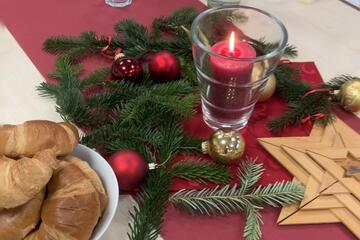 Stilleben: weihnachtlicher tischschmuck mit Kerze und Croissants