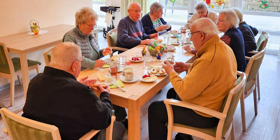 Menschen an einem österlich gedeckten Tisch