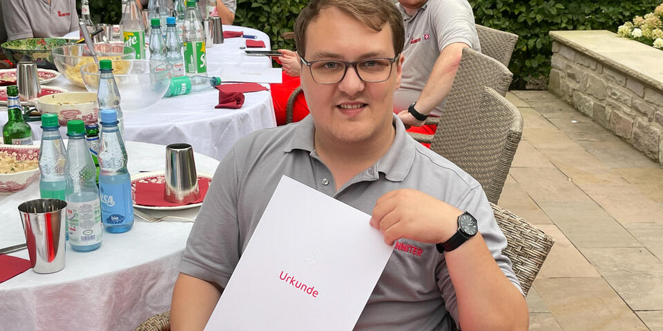 Ein Mann mit einer Urkunde