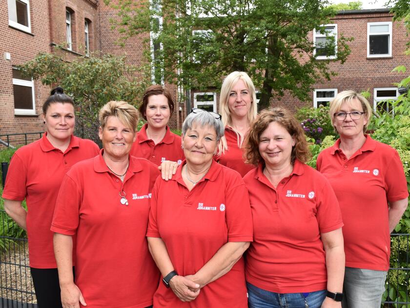 sieben Mitarbeiterinnen der Tagespflege stehen im Garten für ein Gruppenbild zusammen