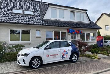 Vor der Logopädiepraxis steht ein PKW der Johanniter