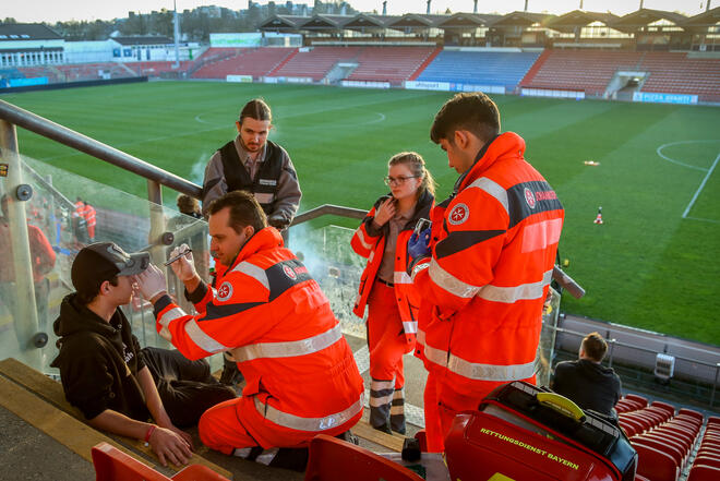 Sanitäter behandeln einen Verletztendarsteller im Fußballstadion Unterhaching