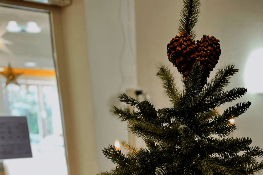 Spitze eines Weihnachtsbaums mit einem herzförmigen Tannenzapfen als Baumspitze.