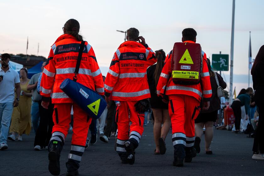 Drei Rettungssanitäter laufen über die Kieler Woche