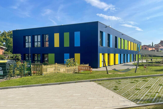 Johanniter-Kita Seehüpfer in Malente Johanniter-Kita Seehüpfer in Malente: Zu sehen ist das blaue Gebäude der Kita mit einem Teil des Außengeländes.