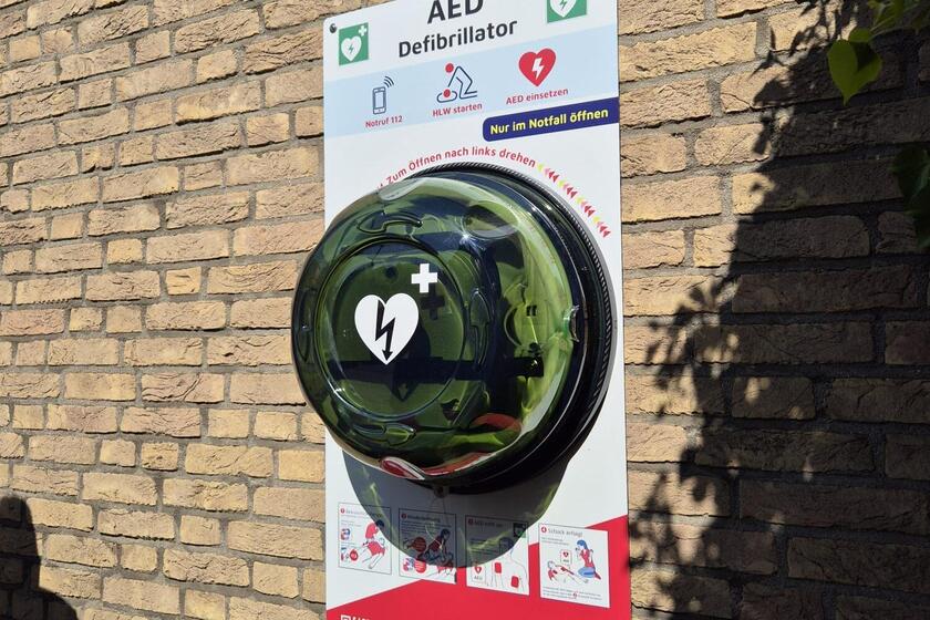 Ein Defibrillator hängt an einer Mauer