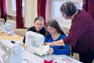 Die ersten Schülererinnen wagen sich an die Nähmaschine