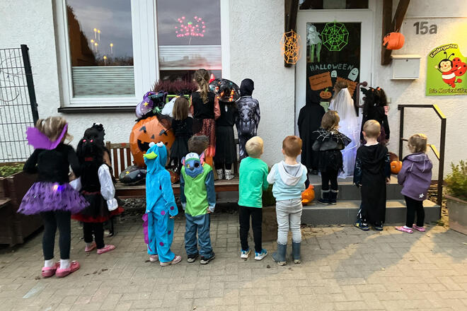 Kostümierte Kinder vor dem Eingang der Kita.