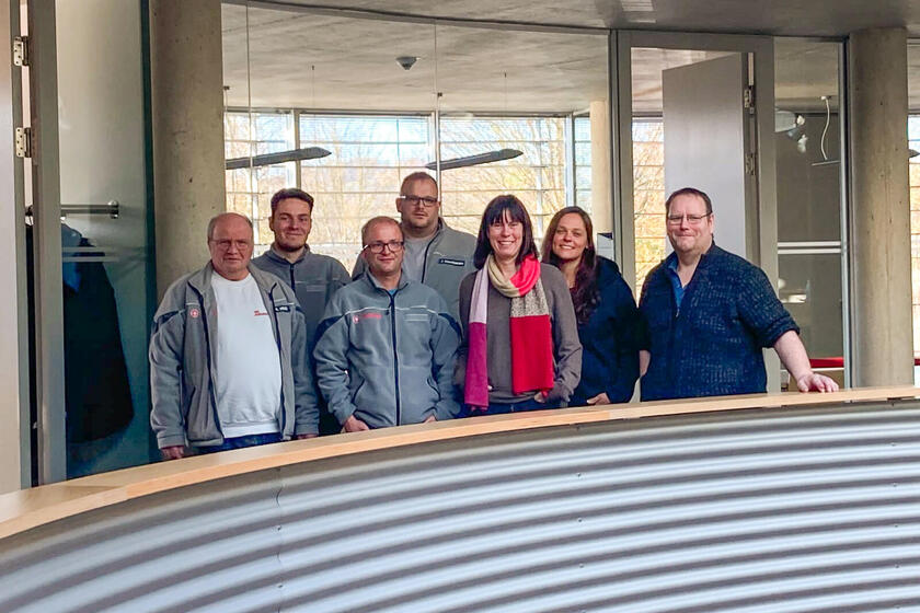Fünf Männer und zwei Frauen stehen in einem runden Raum an einer Balustrade. Teilweise tragen sie Johanniter-Bekleidung. 