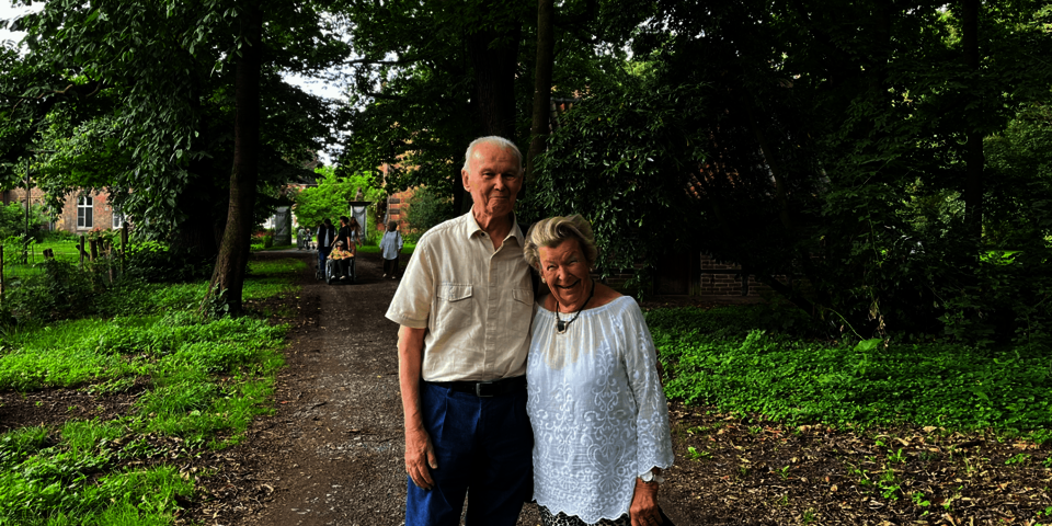 älteres Paar auf einem Spazierweg im Grünen