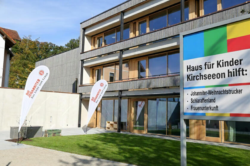 Haus für Kinder mit KI-generierter Spendentafel, die auf Spendenprojekte Hinweist.