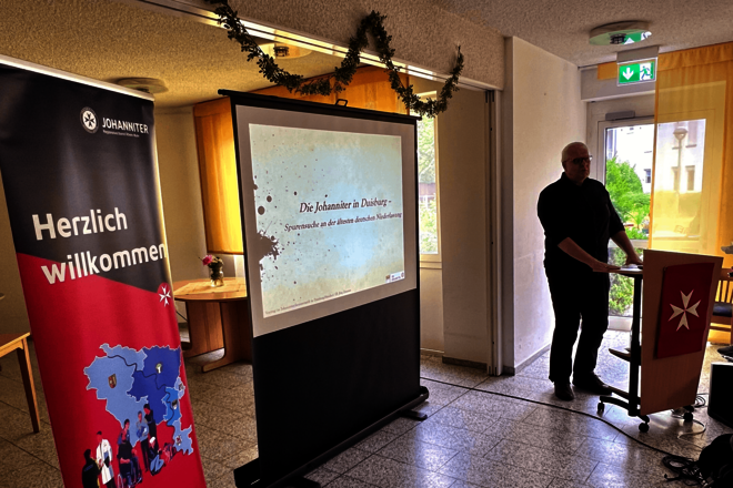 ein Rollup, ein Leinwand und ein Mann an einem Rednerpult