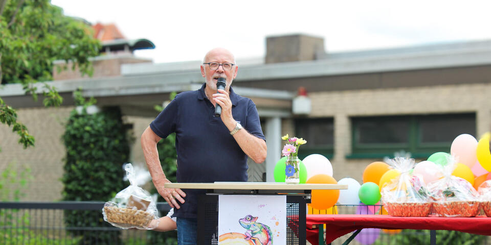 Ein Mann mit Mikrophon auf einer Bühne.