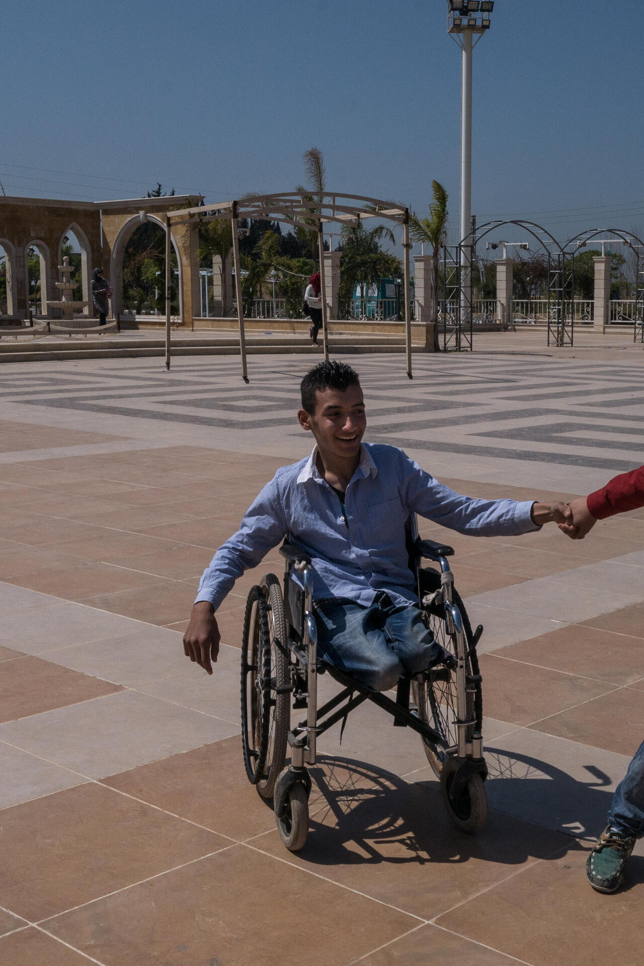 Ein Junge spielt mit einem anderen Jungen der im Rollstuhl sitzt