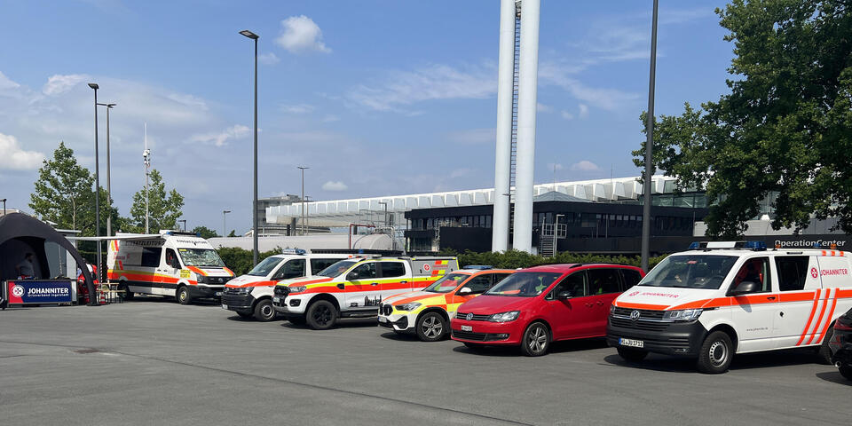 Johanniter-Fahrzeuge vor einem Messegelände