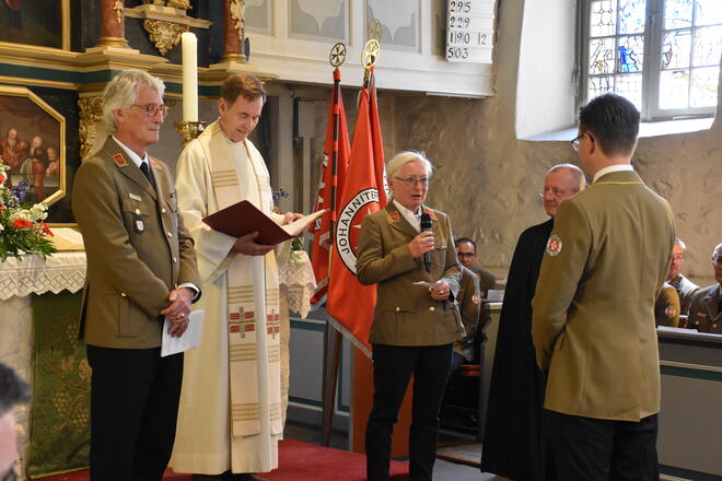 Mehrere Personen stehen vor dem Altar der Kirche.