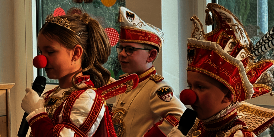 Drei Kinder in traditionellen Karnevalskostümen