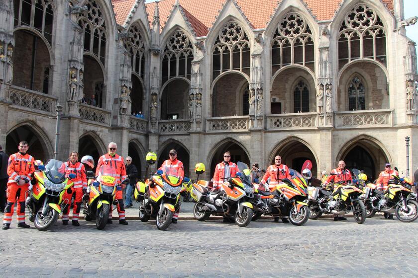 Gruppenfoto der Johanniter in Einsatzkleidung mit Motorrädern. 