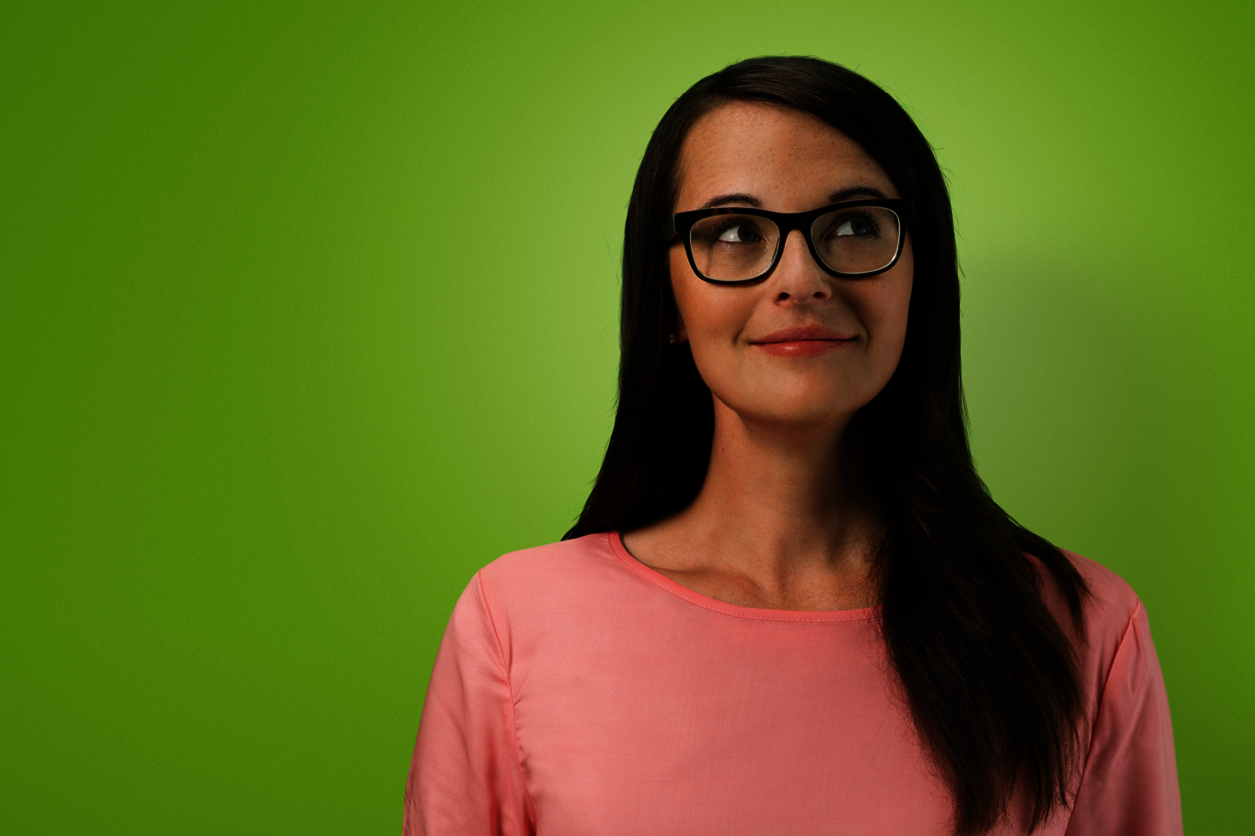 Eine Frau mit Brille auf grünen Hintergrund.