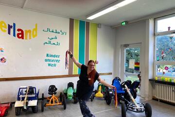 Begleiterin der Gruppe posiert im Kinderland-Raum