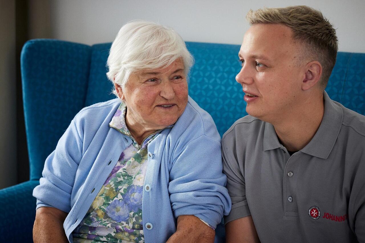 Pflegemitarbeitender und Seniorin