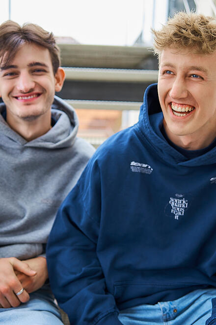 Zwei Freiwilligendienstleistende sitzend lachend auf einer Treppe