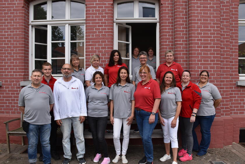 die Mitarbeitenden des Ambulanten Pflegedienstes der Johanniter stehen vor dem roten Backsteingebäude in Salzhausen