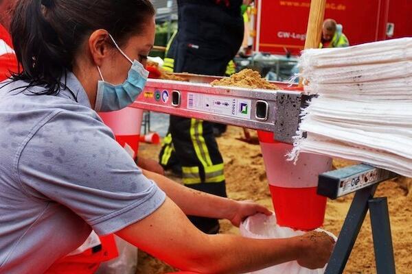 Johanniter-Helferin befüllt Sandsäcke