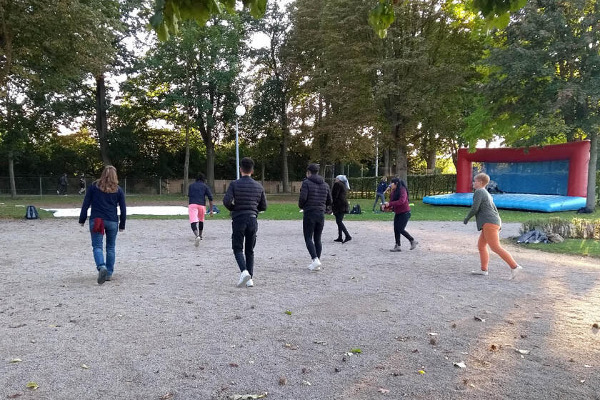 Gemeinsames Aufwärmtraining, die Teilnehmenden hopsen von einem Bein auf das andere.